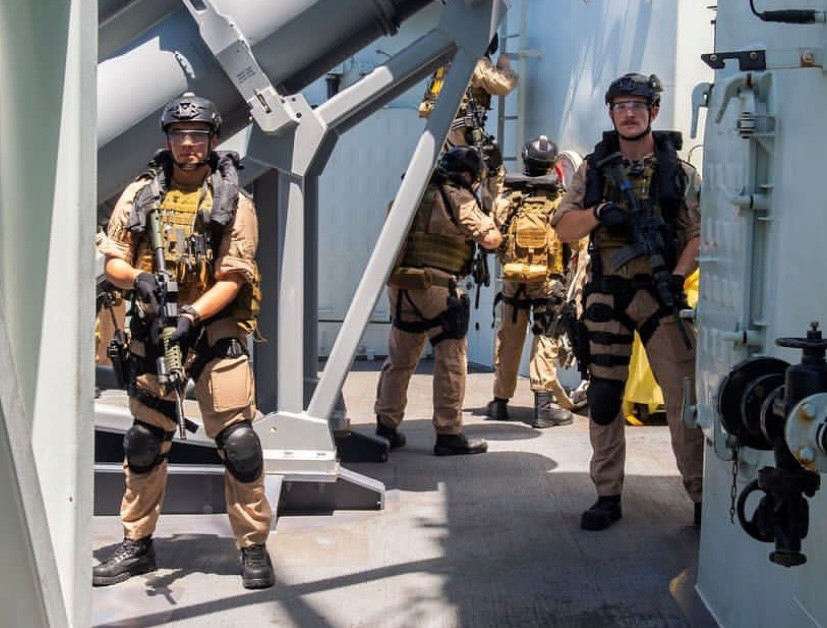 Armed security team in tactical gear aboard a ship.