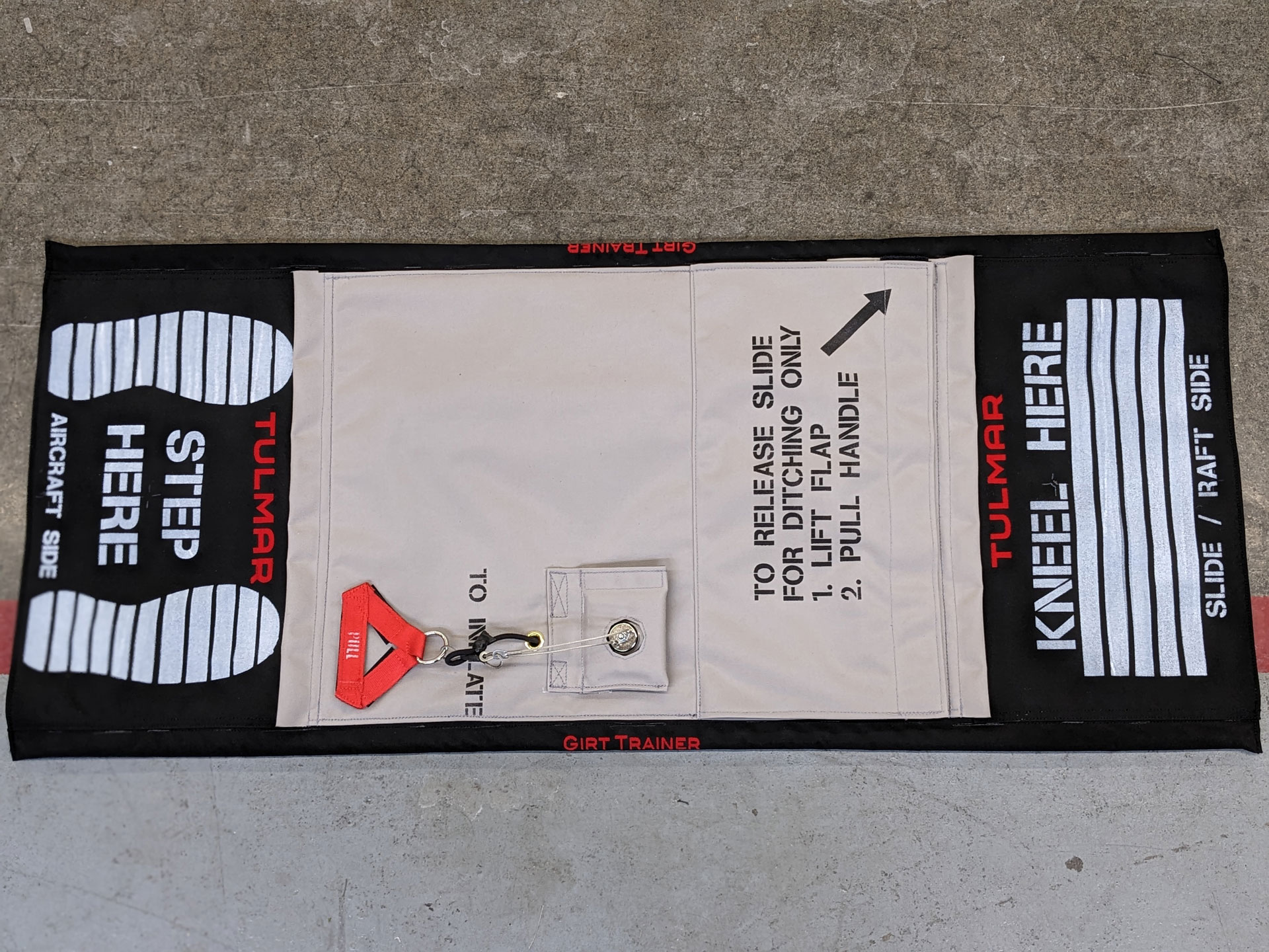 Emergency girt training mat with step and kneel instructions on concrete floor.