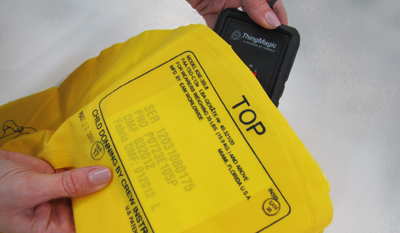 A hand showing part of a yellow life vest with a black care label and the word "TOP" visible.