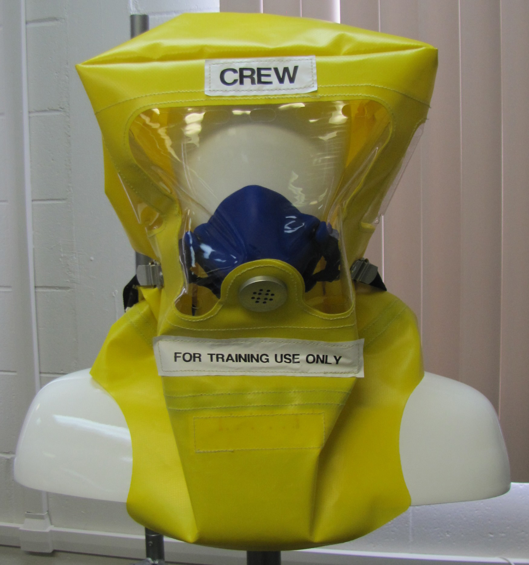 A yellow crew emergency training oxygen mask with a transparent face cover.