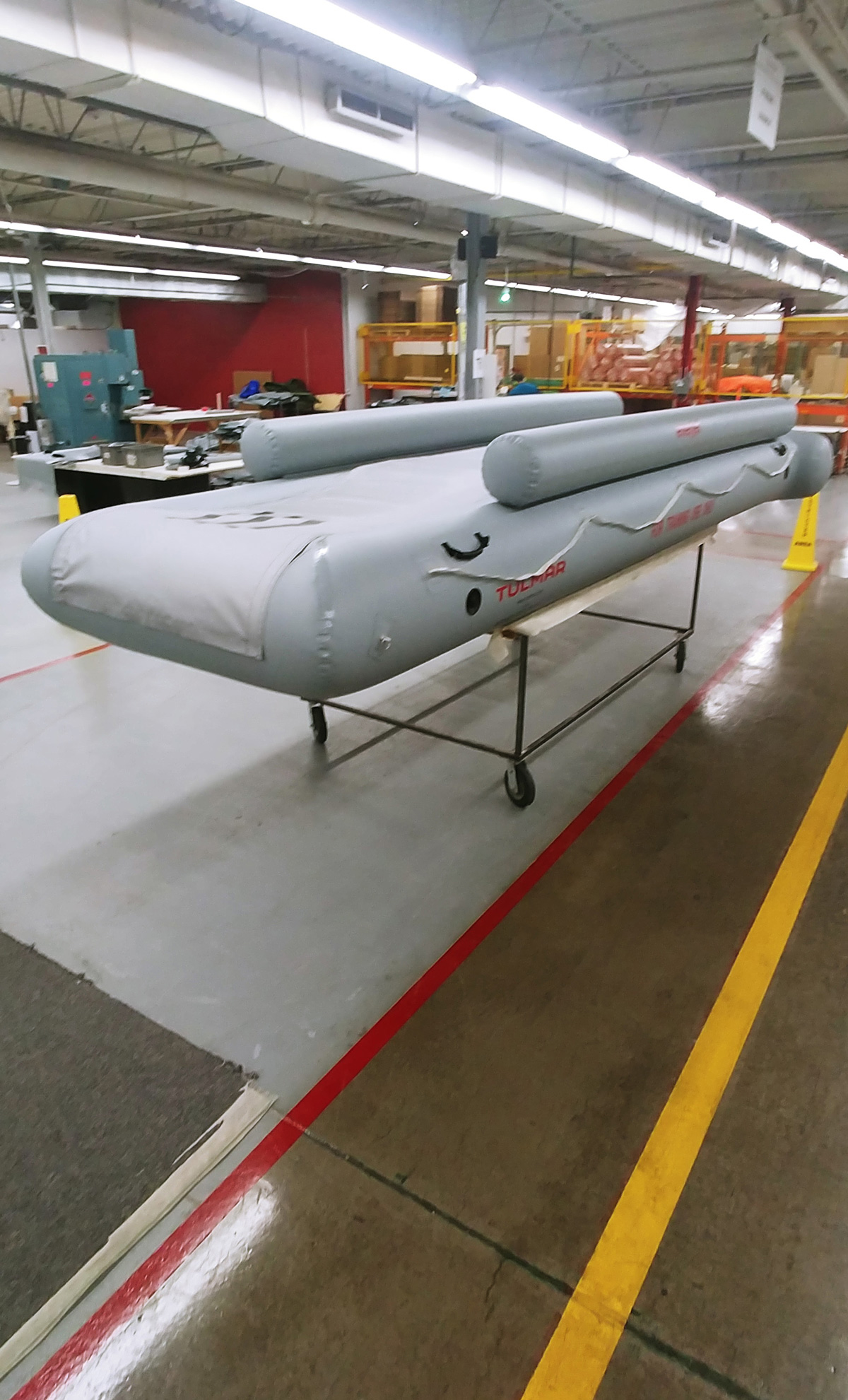 Inside a warehouse, a large inflatable emergency slide, awaiting use testing.